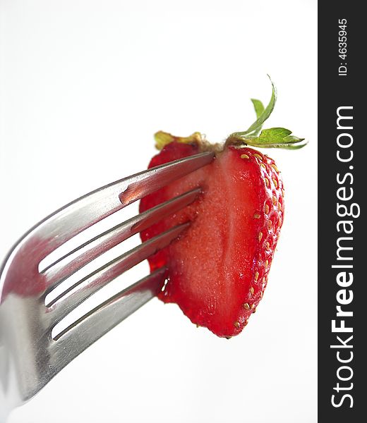 Strawberry colopuncture on fork on white background