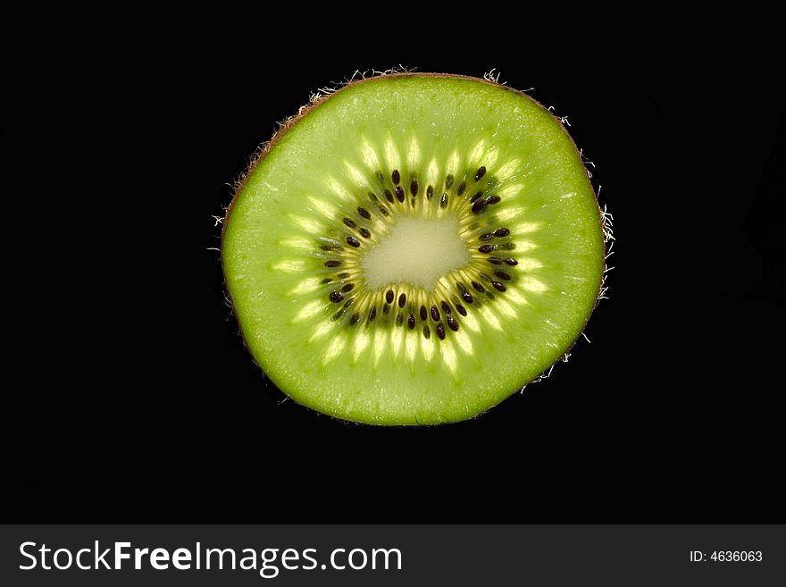 Slice of kiwi isolated in a black background