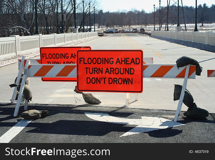 A Flooded roadway sign on a bridge