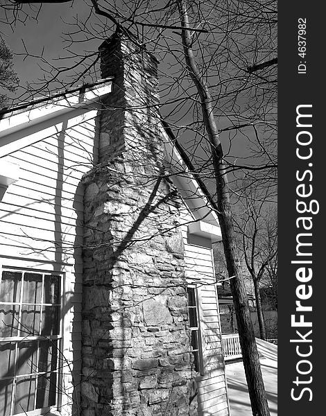 A stone chimney on an old farmhouse in black and white. A stone chimney on an old farmhouse in black and white