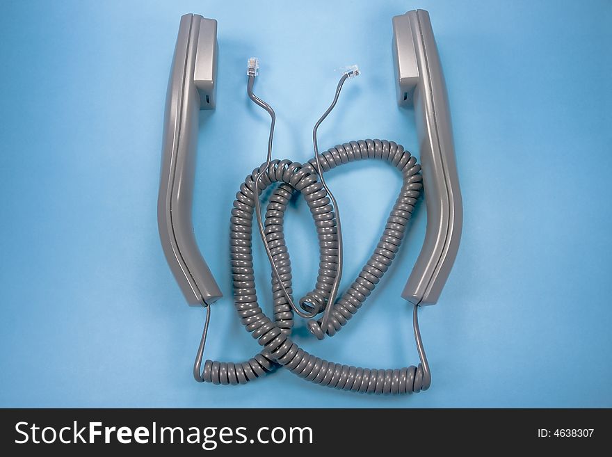 Two unplugged phone handsets on blue background. Two unplugged phone handsets on blue background