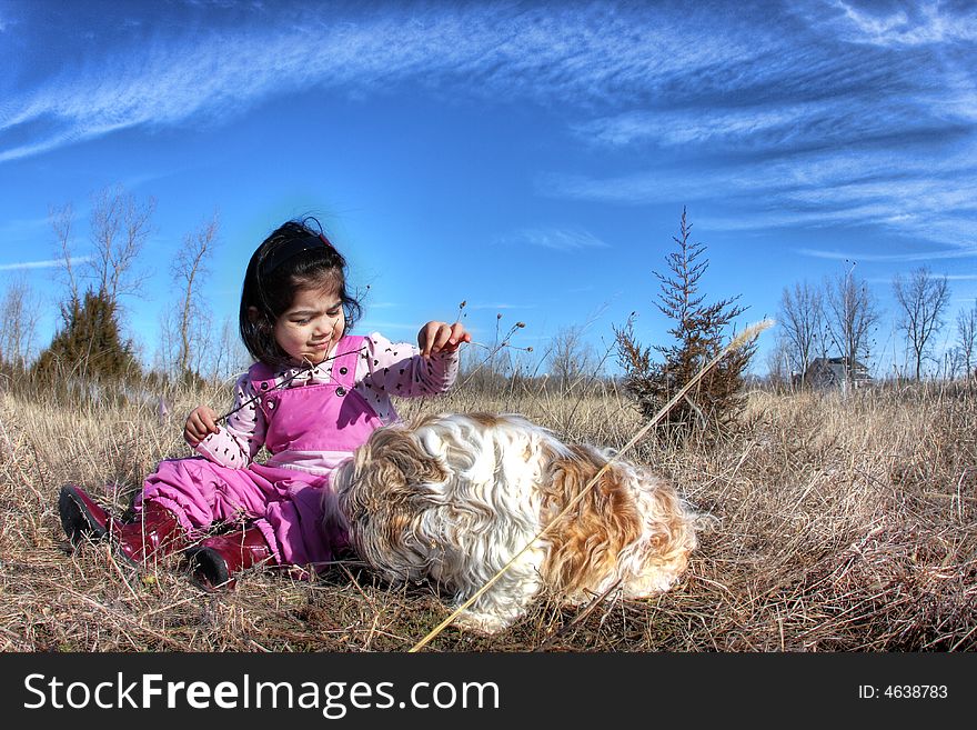 Toddler playing with her dogg in the field. Toddler playing with her dogg in the field