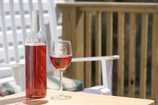 Wine And Glass On Deck With White Chair Royalty Free Stock Images