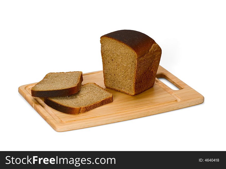 Loaf of rye bread and two bread slices on kitchen board