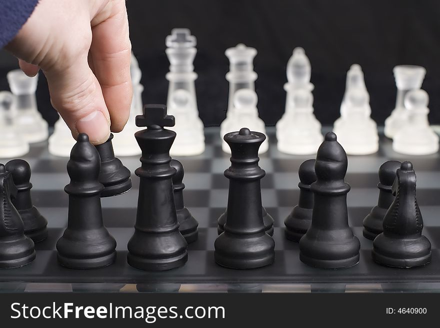 The first move in a game of chess, shallow depth of field focusing on players hand. The first move in a game of chess, shallow depth of field focusing on players hand