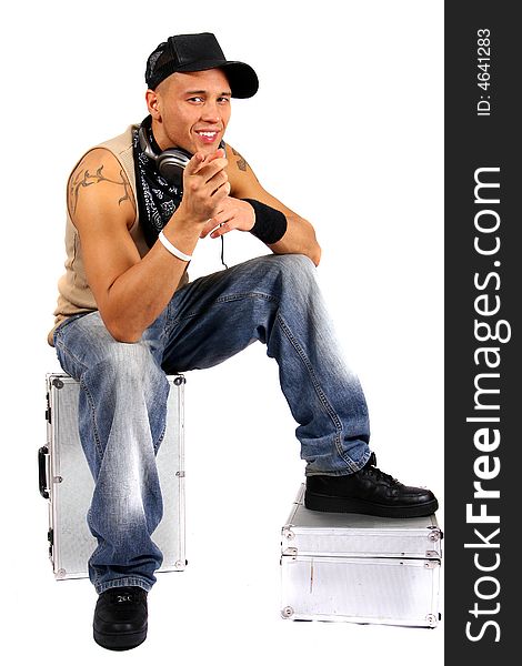 Young man sitting on dj cases with headphones and lots of tattoos. Young man sitting on dj cases with headphones and lots of tattoos.