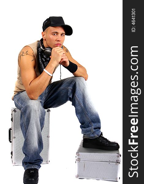 Young man sitting on dj cases with headphones and lots of tattoos. Young man sitting on dj cases with headphones and lots of tattoos.