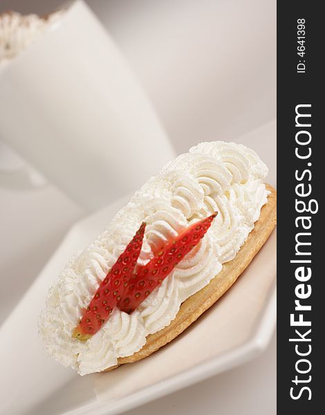 Cream dessert with strawberry on white plate