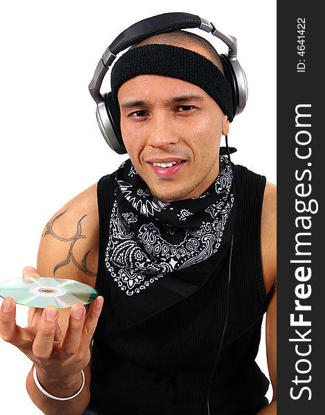 A young man with headphones in black with lots of tattoos is looking at a disc. A young man with headphones in black with lots of tattoos is looking at a disc.