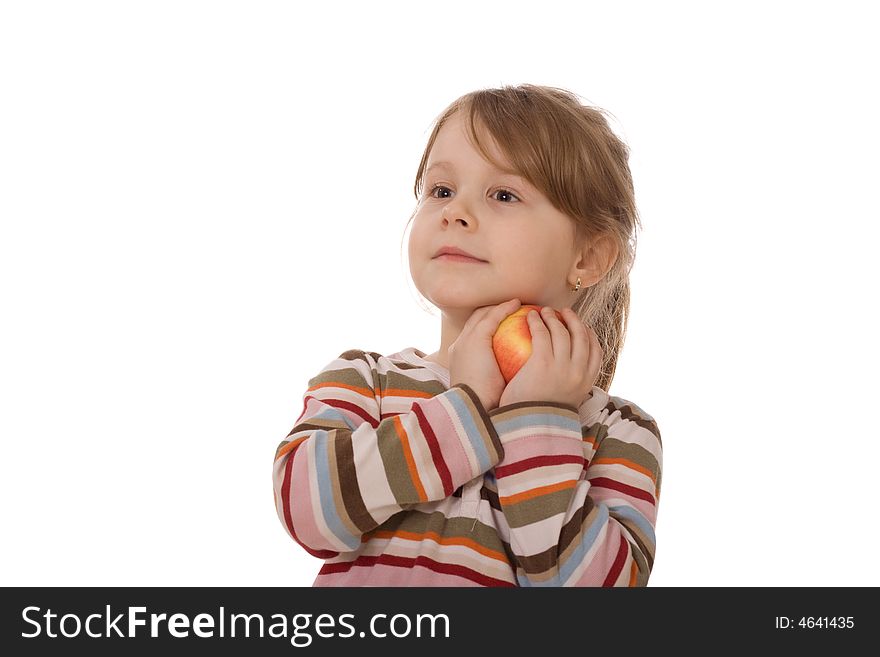 The child with an apple, on a white background, looks in a distance