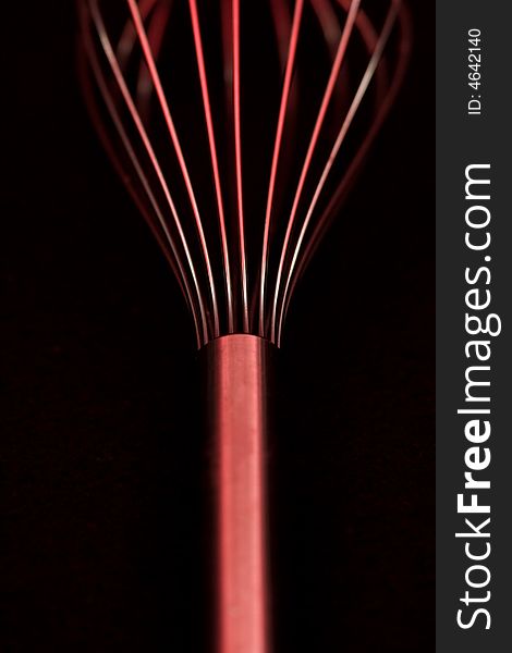 Metallic whisk with a sensual red light. Metallic whisk with a sensual red light