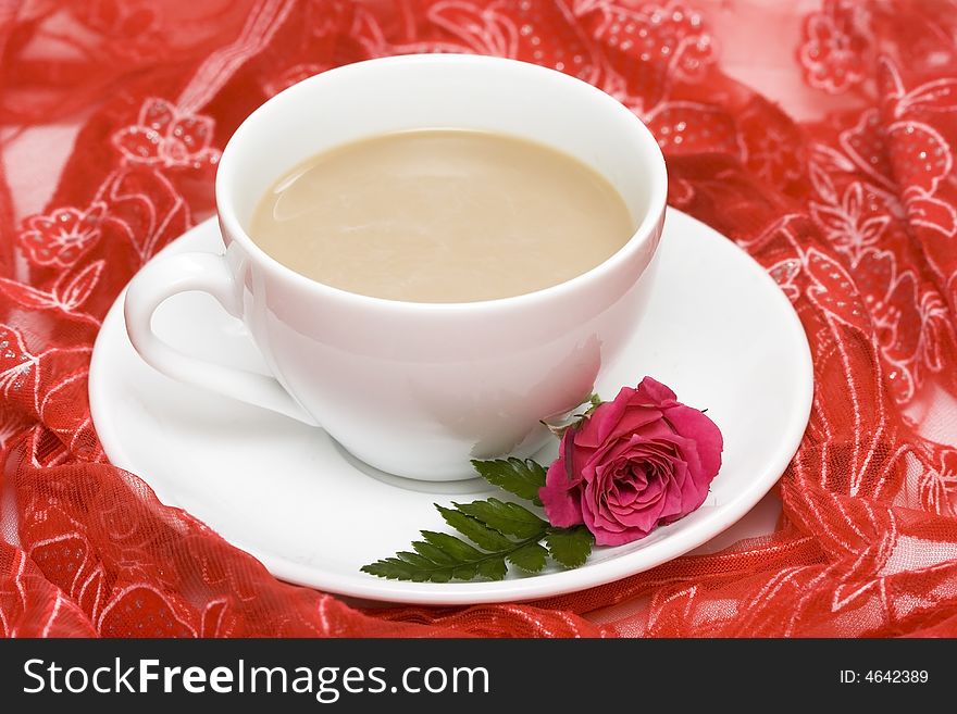 White cup of coffee with red rose