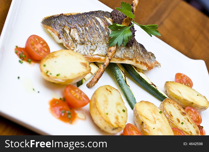 Healthy lunch dish in modern british restaurant, with clean white crockery. sea bass with vegetables. Healthy lunch dish in modern british restaurant, with clean white crockery. sea bass with vegetables