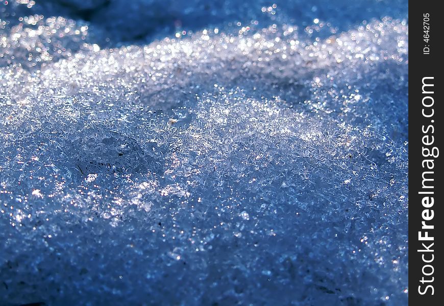 Macro shot of blue snow crystals lit by the winter sun. Macro shot of blue snow crystals lit by the winter sun.