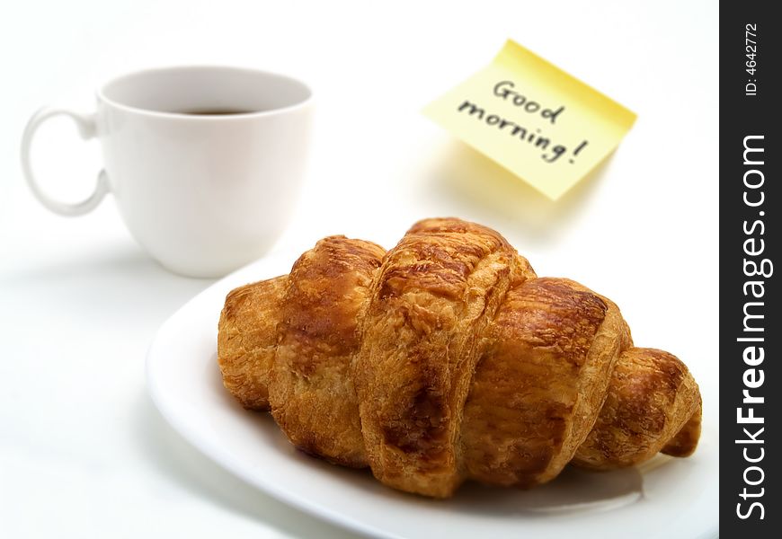 A Croissant, A Cup Of Coffee And A Yellow Note