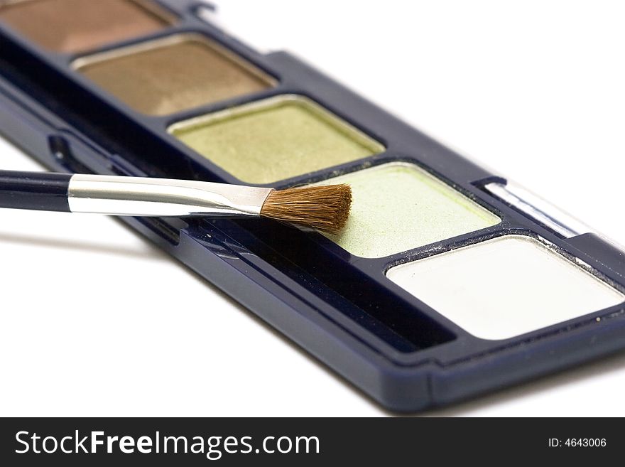 Green make-up eyeshadows and cosmetic brush