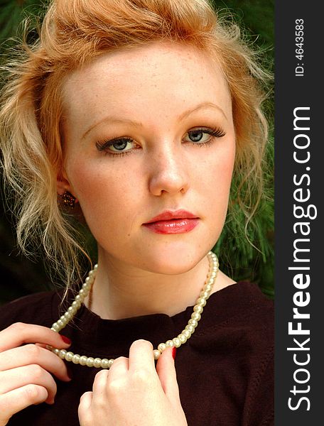 Young blond woman in outdoor location with pearls. Young blond woman in outdoor location with pearls