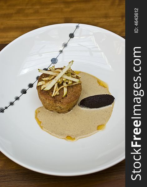 Modern british cafe with apple sponge pudding, apple slices, raisin puree, coffee sauce and funky crockery. Modern british cafe with apple sponge pudding, apple slices, raisin puree, coffee sauce and funky crockery