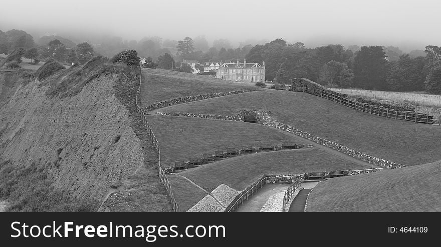 Foggy coastline and fields with manor house at Sidmouth in Devon UK. Foggy coastline and fields with manor house at Sidmouth in Devon UK