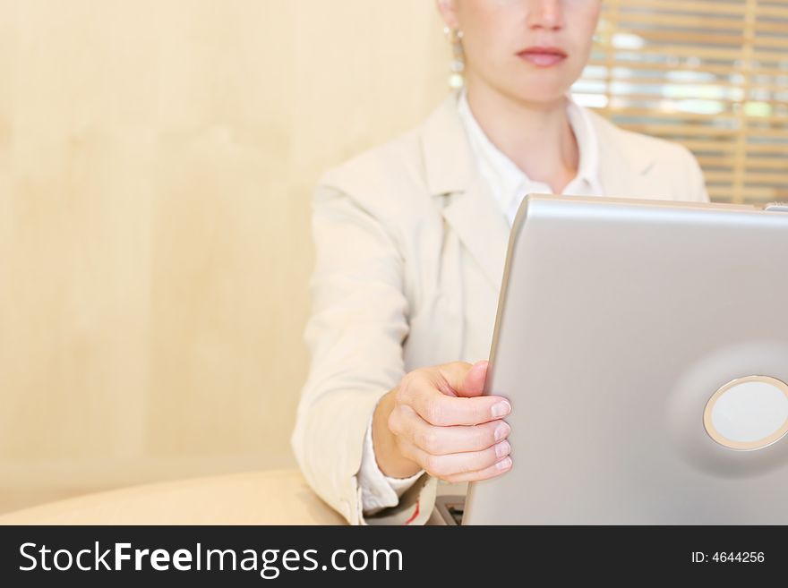 Single white business woman sitting at table adjusting laptop screen. Single white business woman sitting at table adjusting laptop screen