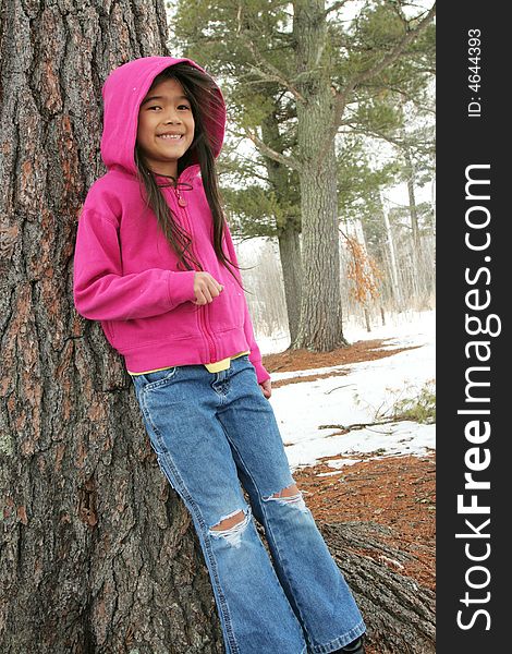 Six year old girl standing under tree in winter. Six year old girl standing under tree in winter