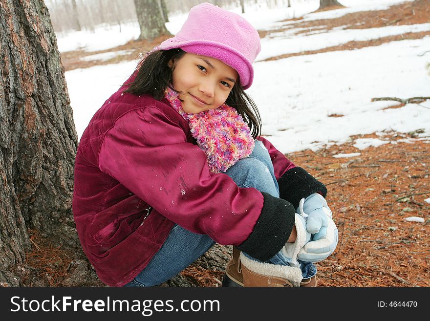 Nine Year Old Girl Sitting Outdoors In Winter