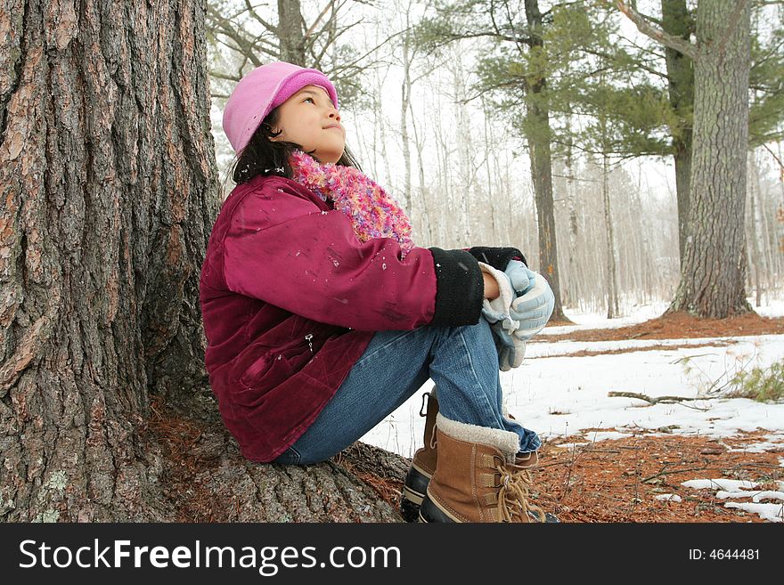 Nine year old girl sitting outdoors in winter