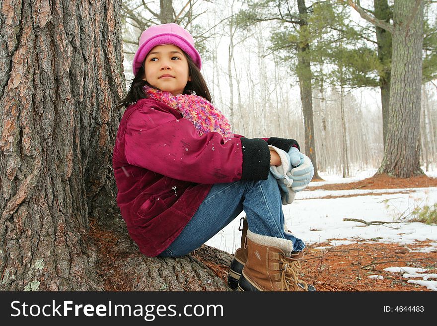 Nine Year Old Girl Sitting Outdoors In Winter