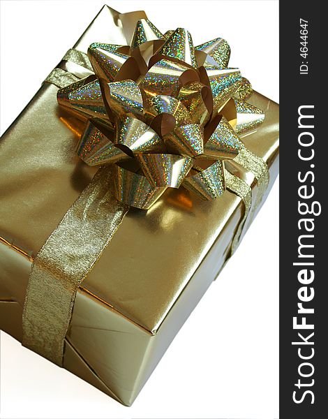 Luxurious gold gift wrapped with glittery golden bow and ribbons isolated on white. Luxurious gold gift wrapped with glittery golden bow and ribbons isolated on white