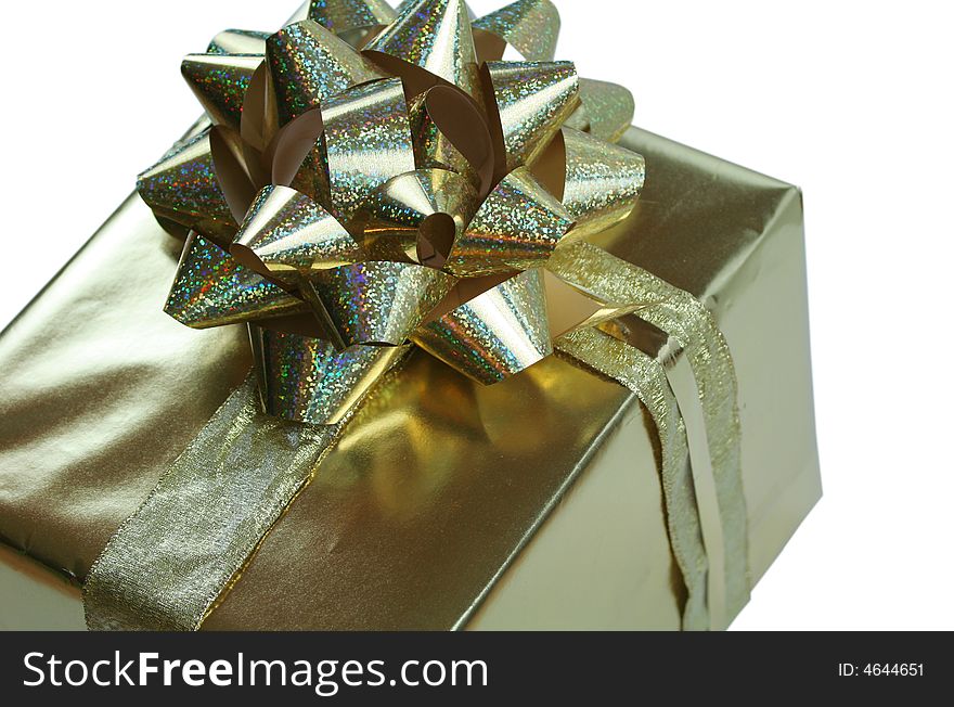 Luxurious gold gift wrapped with glittery golden bow and ribbons isolated on white. Luxurious gold gift wrapped with glittery golden bow and ribbons isolated on white