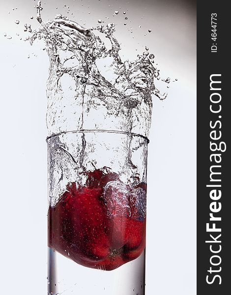 A healthy apple dropping in water on white isolated background. A healthy apple dropping in water on white isolated background.