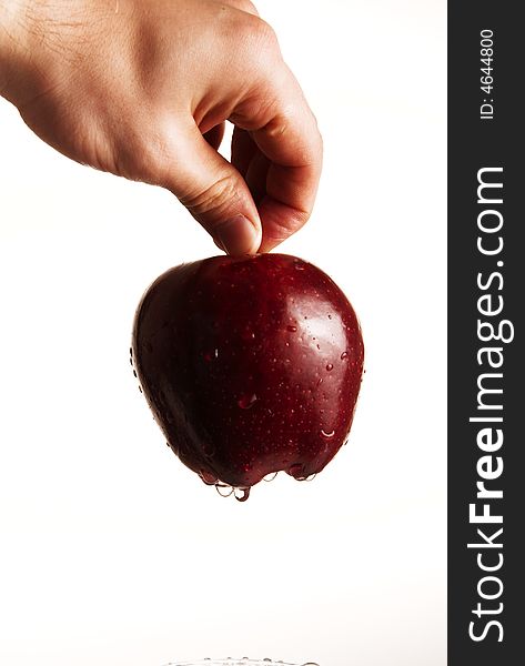 A human hand holding a red delicious apple. A human hand holding a red delicious apple