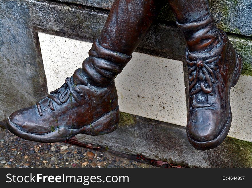 Cast bronze boots of statue, outside turning a patina color