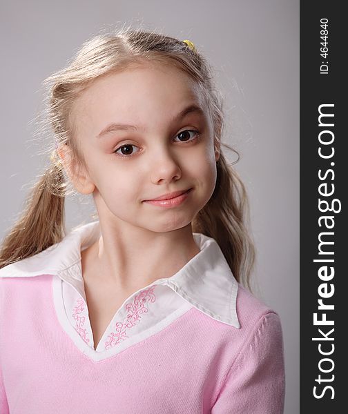 A studio shot of a cute little girl on a gray background