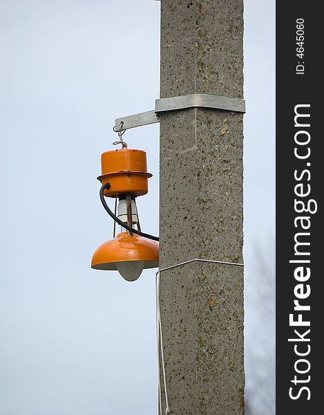The bright orange electric lantern hangs on a column