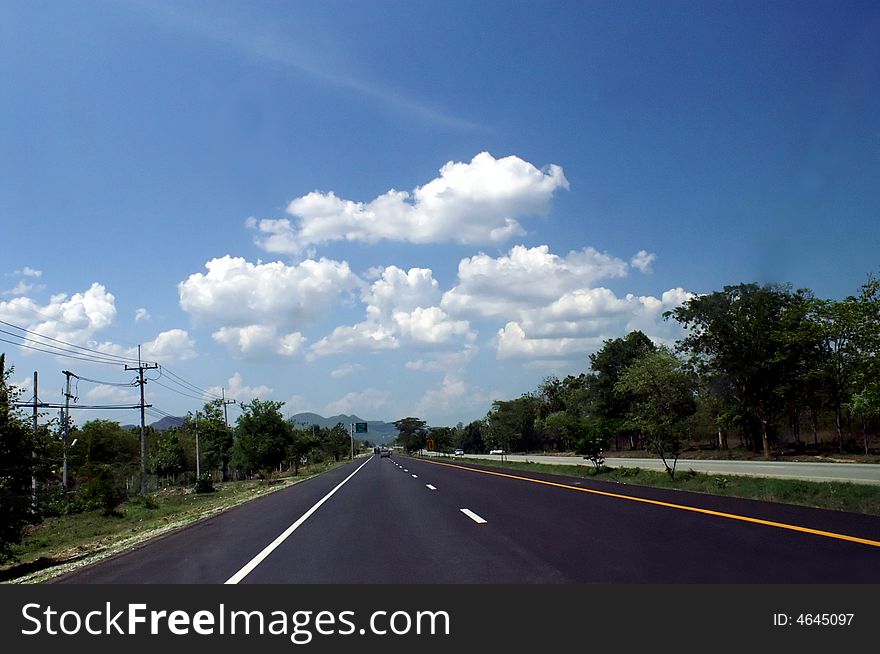 Long empty road in blue sky