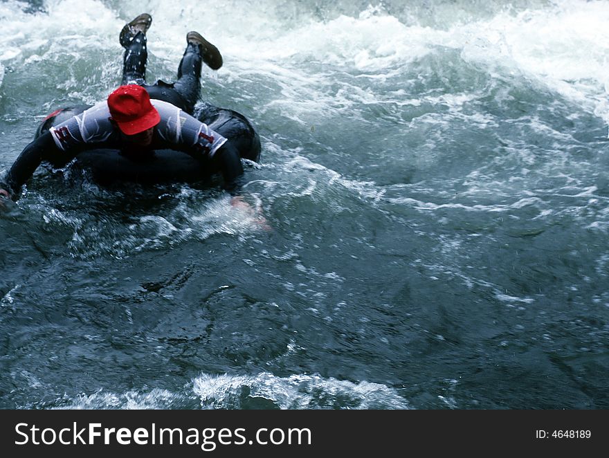 A man on an innertube going through some rapids. A man on an innertube going through some rapids