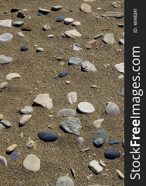 Texture of scattered pebbles on a sandy beach. Texture of scattered pebbles on a sandy beach