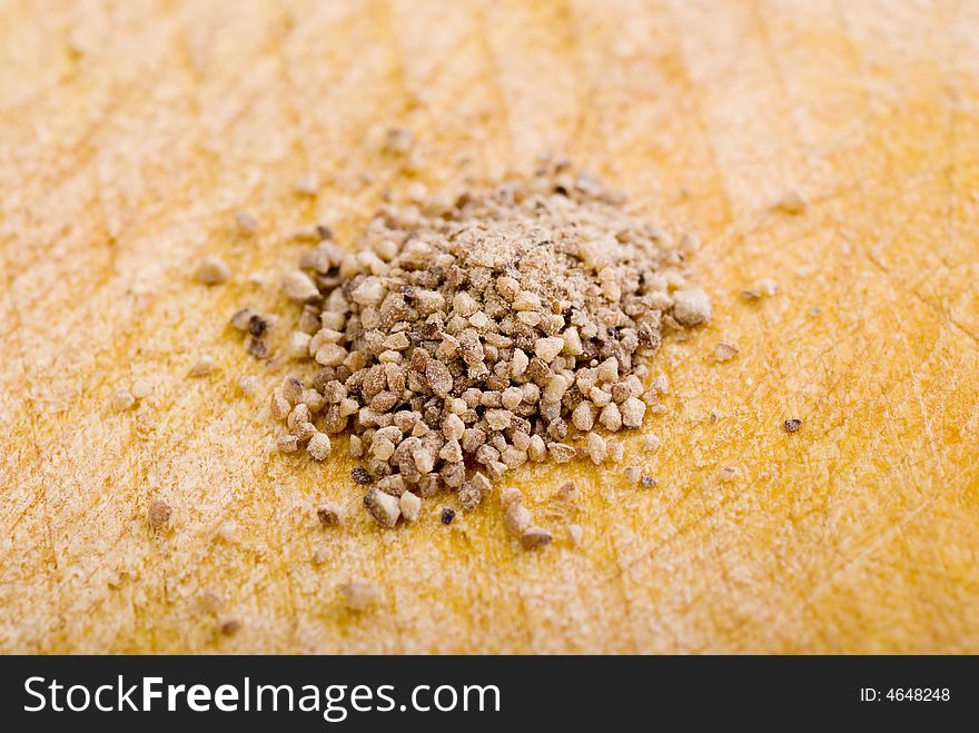 Pile of spice grains on a wooden board. Pile of spice grains on a wooden board