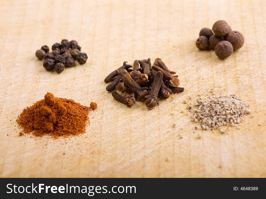 Five piles of spice grains on a wooden board - photo from the angle. Five piles of spice grains on a wooden board - photo from the angle