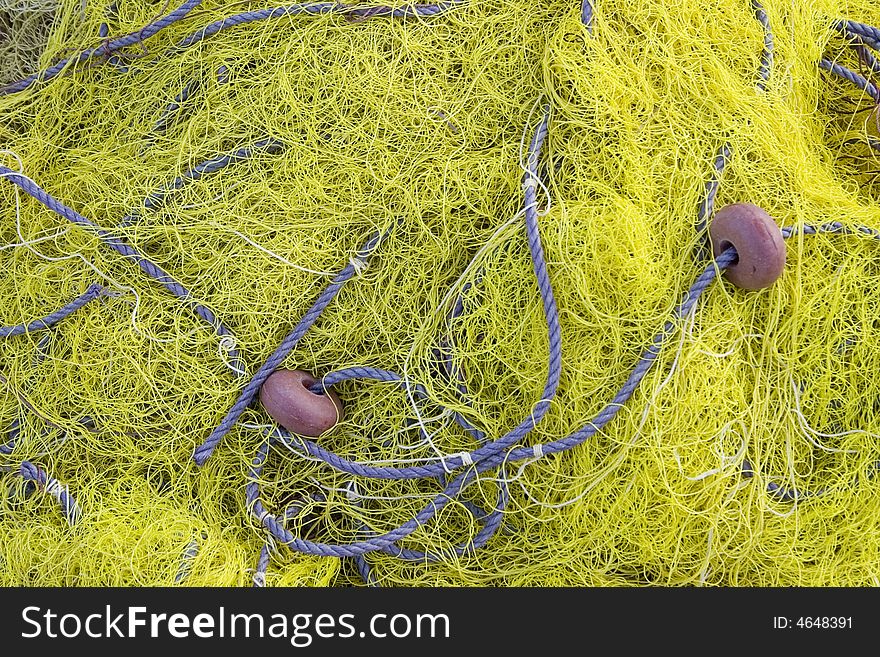 Detail of a yellow fishing net on the quayside. Detail of a yellow fishing net on the quayside