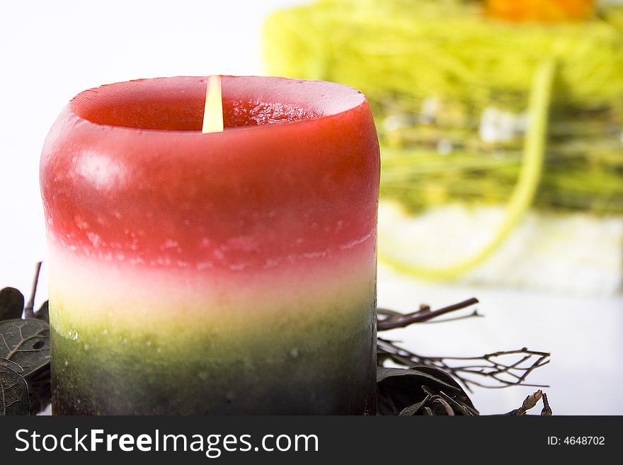 Red-green candle with basketry on background