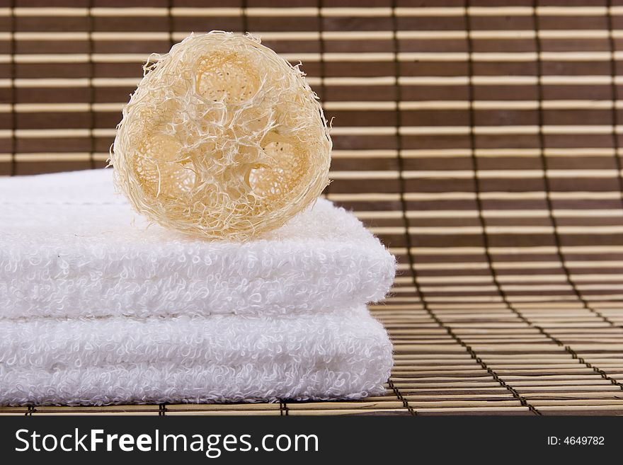 A natural sponge and two white towels