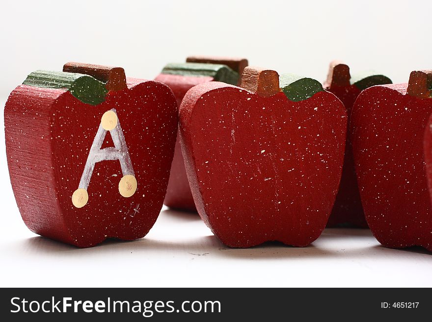 Wooden Apples with the letter A painted on it.