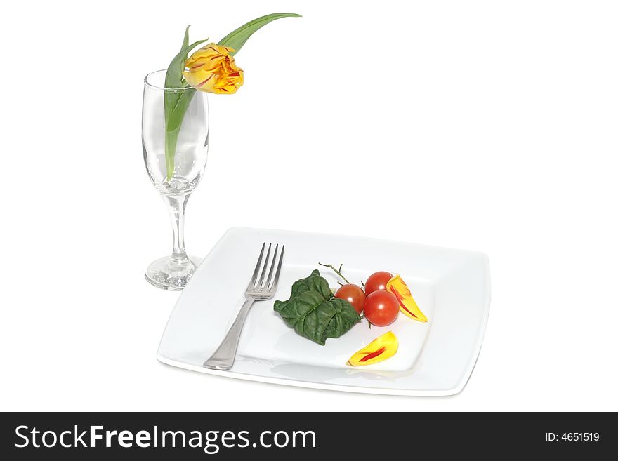 Still life of vegetables on a plete and flower in a glass. Still life of vegetables on a plete and flower in a glass