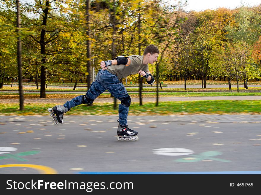 Roller skating at autumnal park.