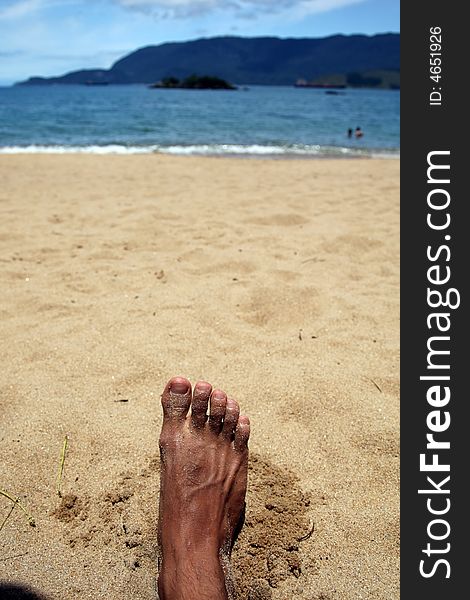 Sandy feet relaxing on a tropical beach in brazil. Sandy feet relaxing on a tropical beach in brazil