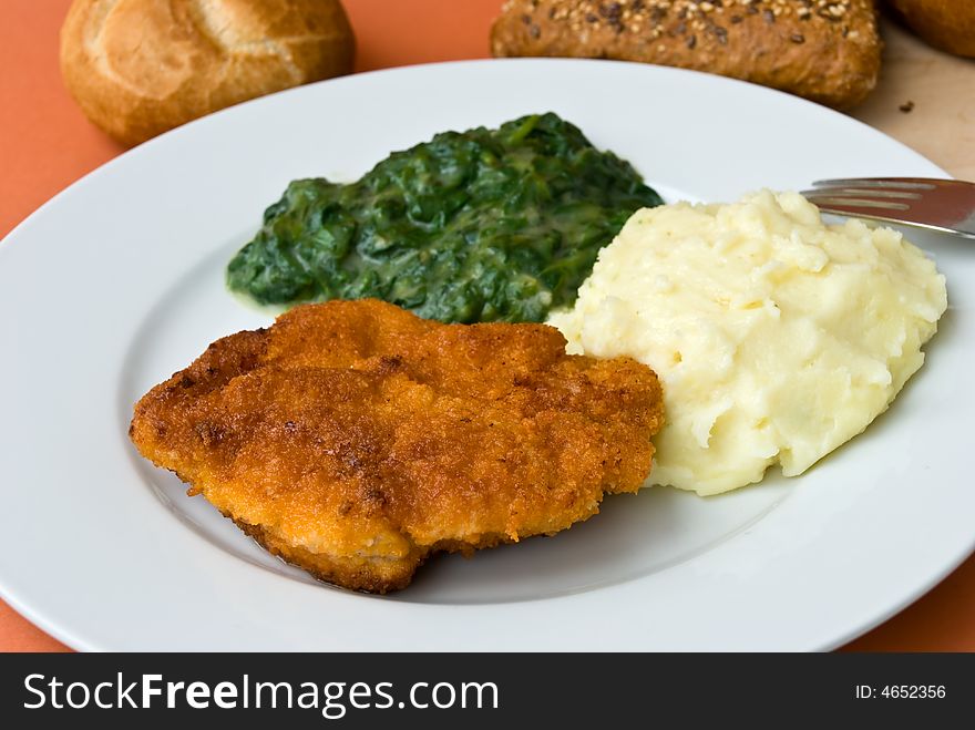 Fried cutlet with spinach and puree.