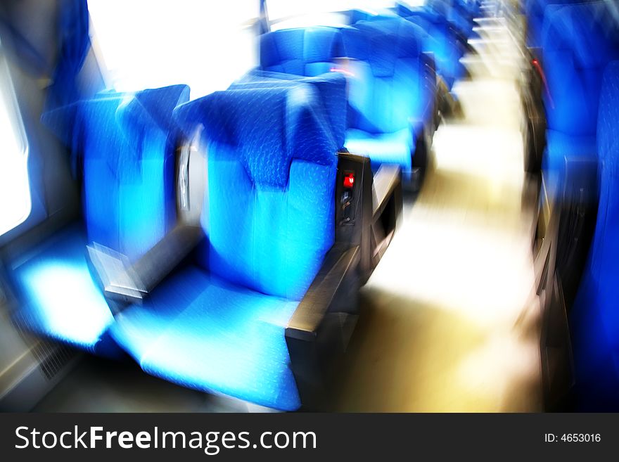 Vacant seats inside an empty passenger train. Horizontal frame. Blur effect. Vibrant colors. Vacant seats inside an empty passenger train. Horizontal frame. Blur effect. Vibrant colors