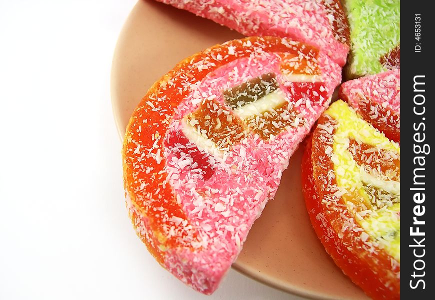 Beautiful fruit candy on a plate on a white background